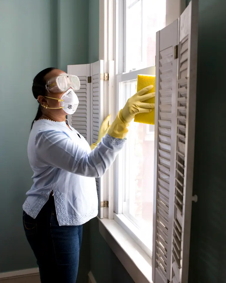 Professional cleaner wiping a kitchen surface with a microfiber cloth